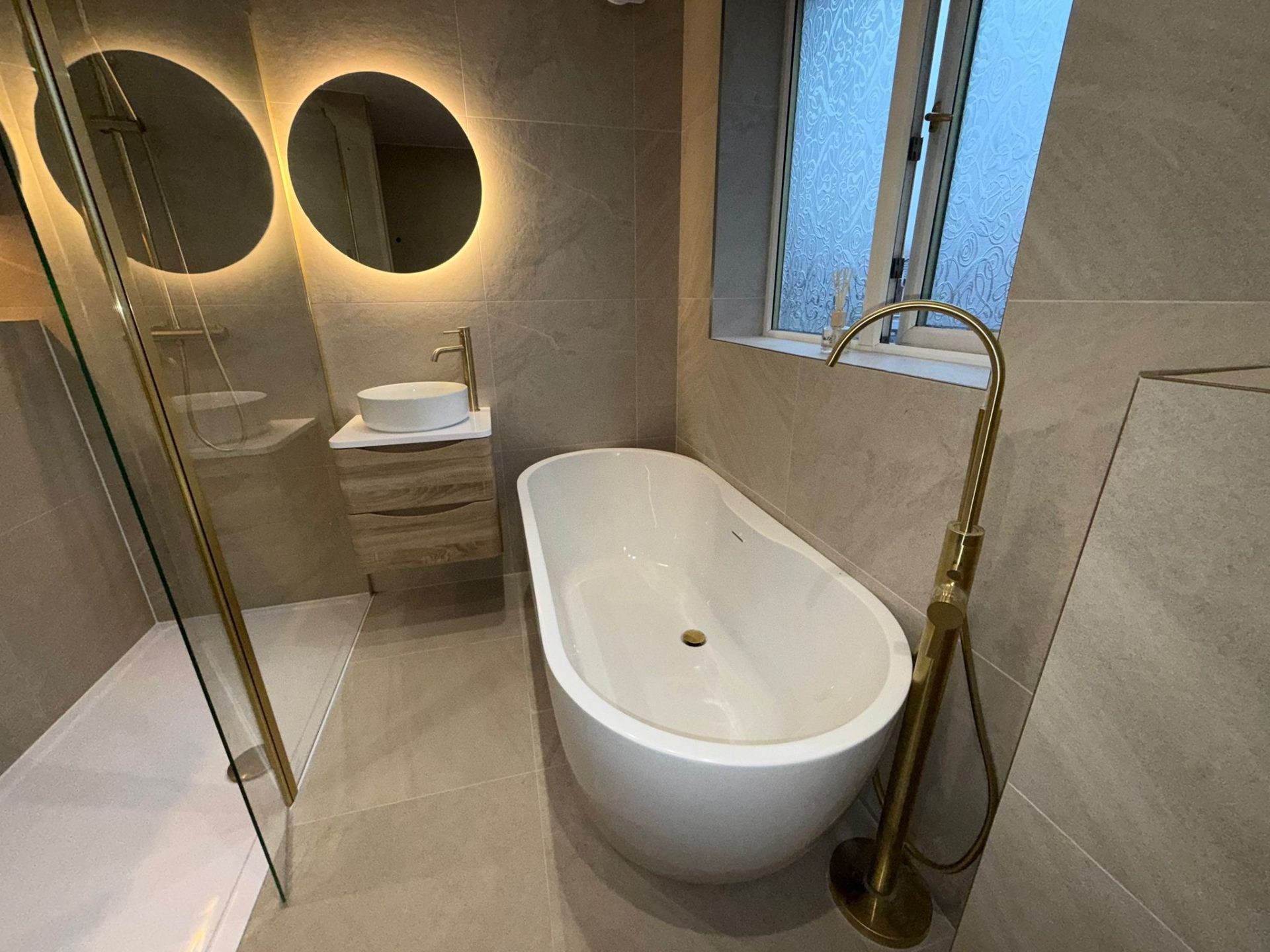 Premium bathroom with freestanding bath, vessel basin vanity, and LED mirror installed in Manchester