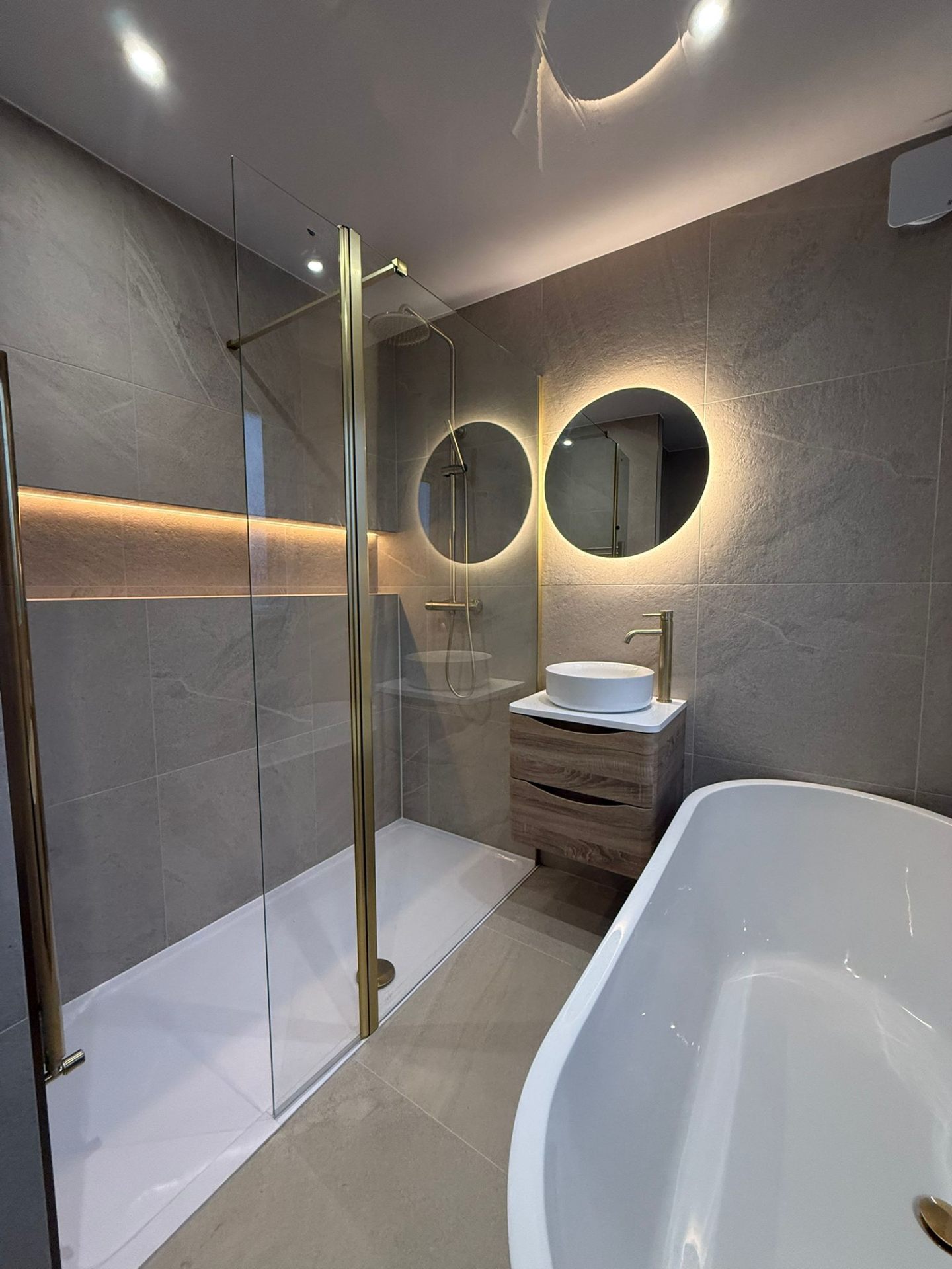 Modern bathroom renovation showing luxury walk-in shower and wall-hung vanity in a Manchester home