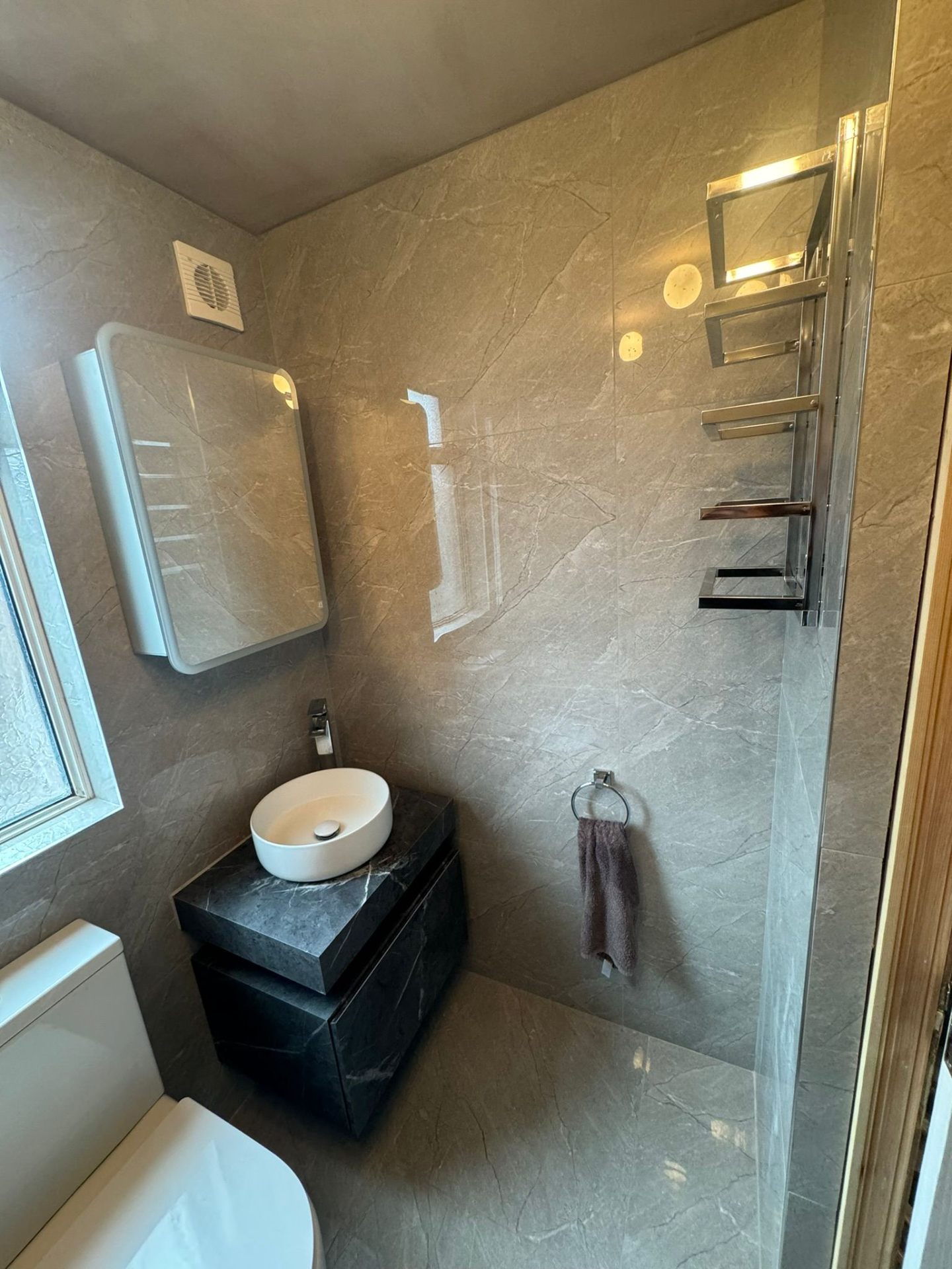 Compact modern bathroom with wall-hung fixtures and clever storage solutions maximising space